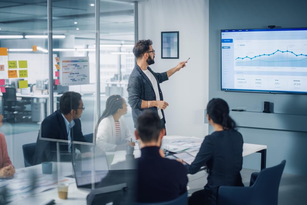A board chair leading a board meeting after reading a guide on how to run a board meeting