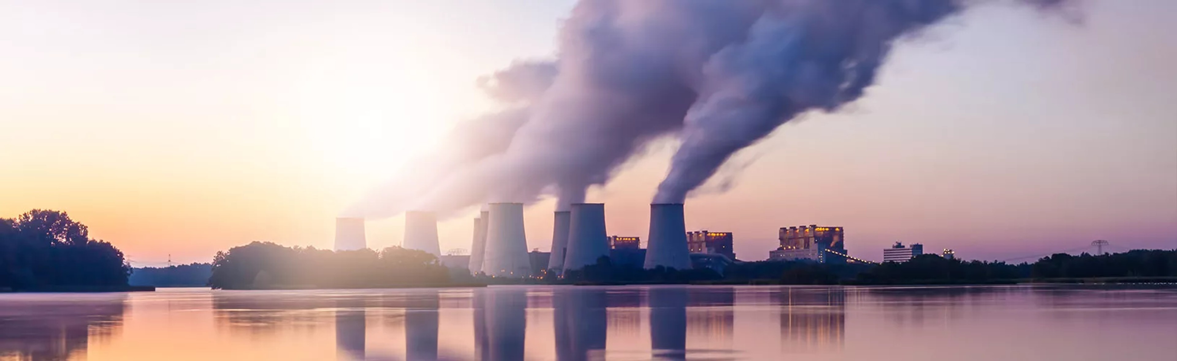Chemicals not yet regulated in the US, but cause, or are suspected of causing, harm are being dispersed into the environment from factories. Scene is of these factories at sunset, with chemicals filling the air and the buildings themselves creating a reflection over the water.