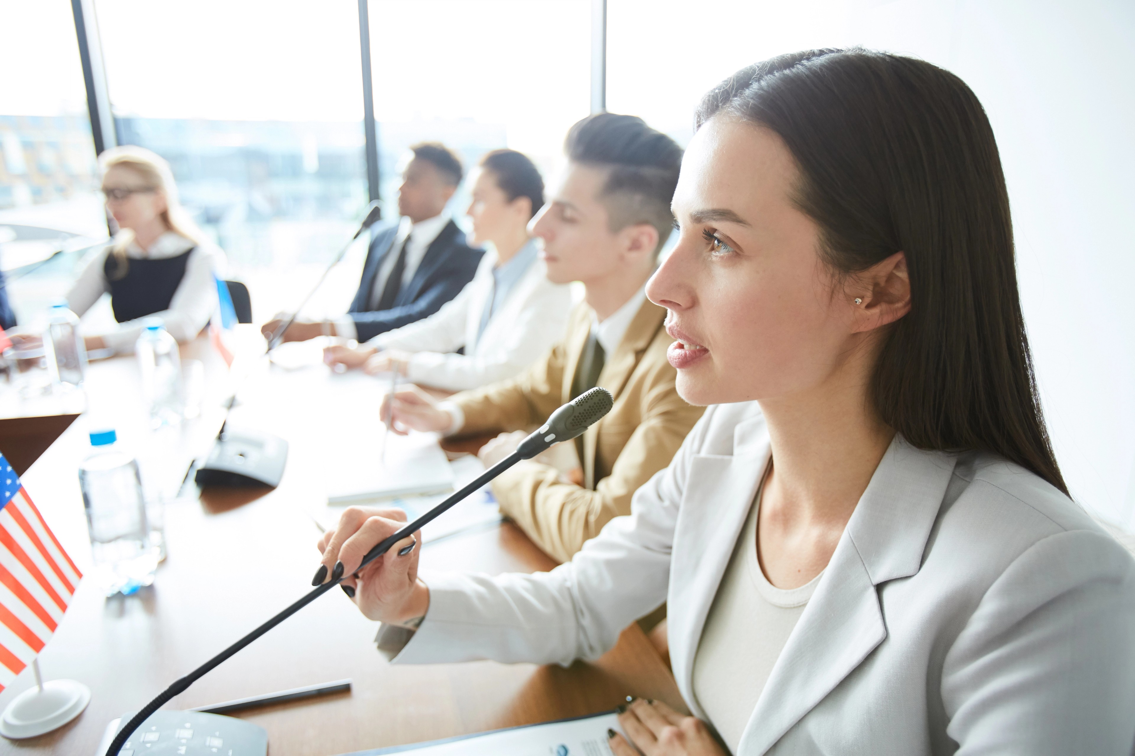 a publicly elected female board member speaks into a microphone to discuss a contentious vote