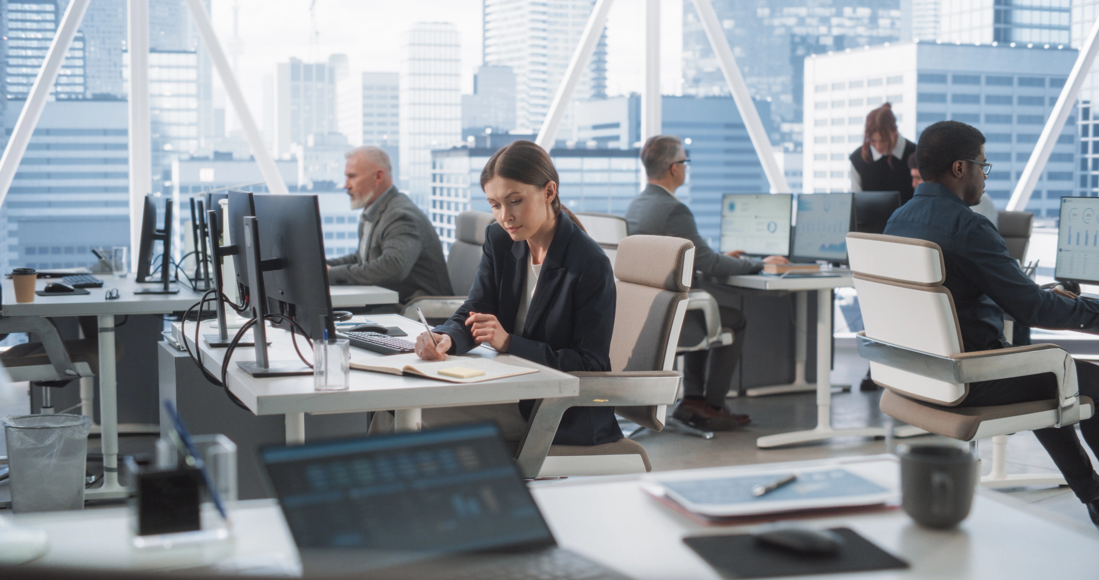 Woman working in a high-rise office with several colleagues