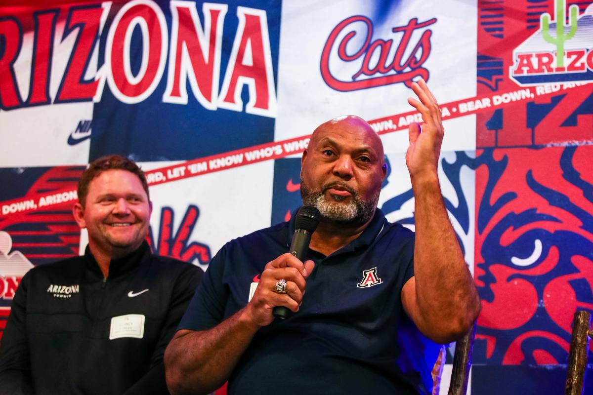 Ricky Hunley speaking with a microphone on a Wildcats panel