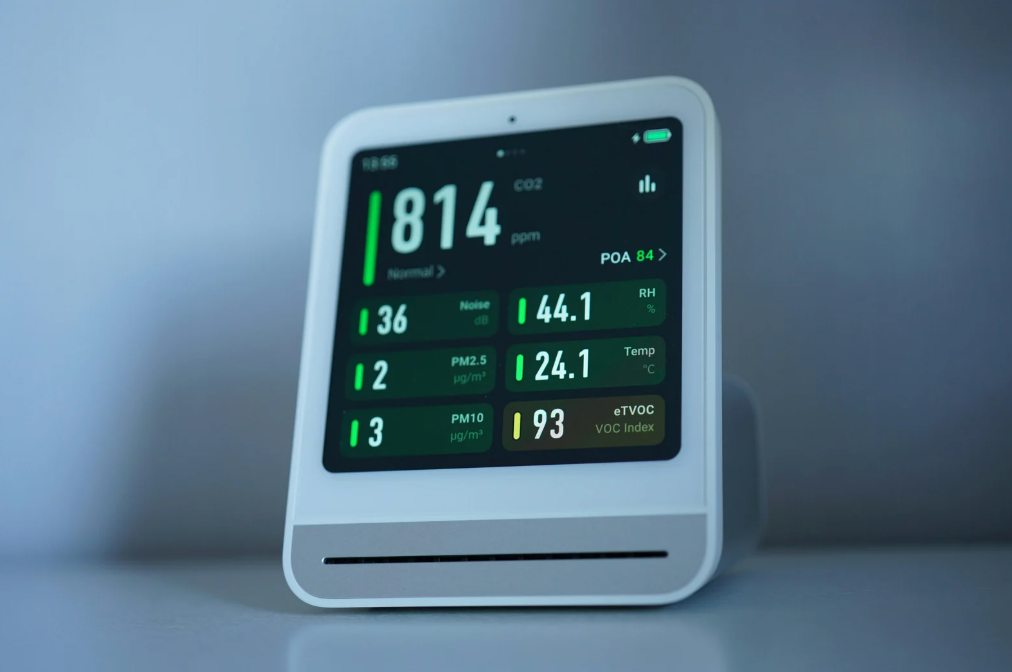 alt text: Smart thermostat displaying indoor temperature and humidity