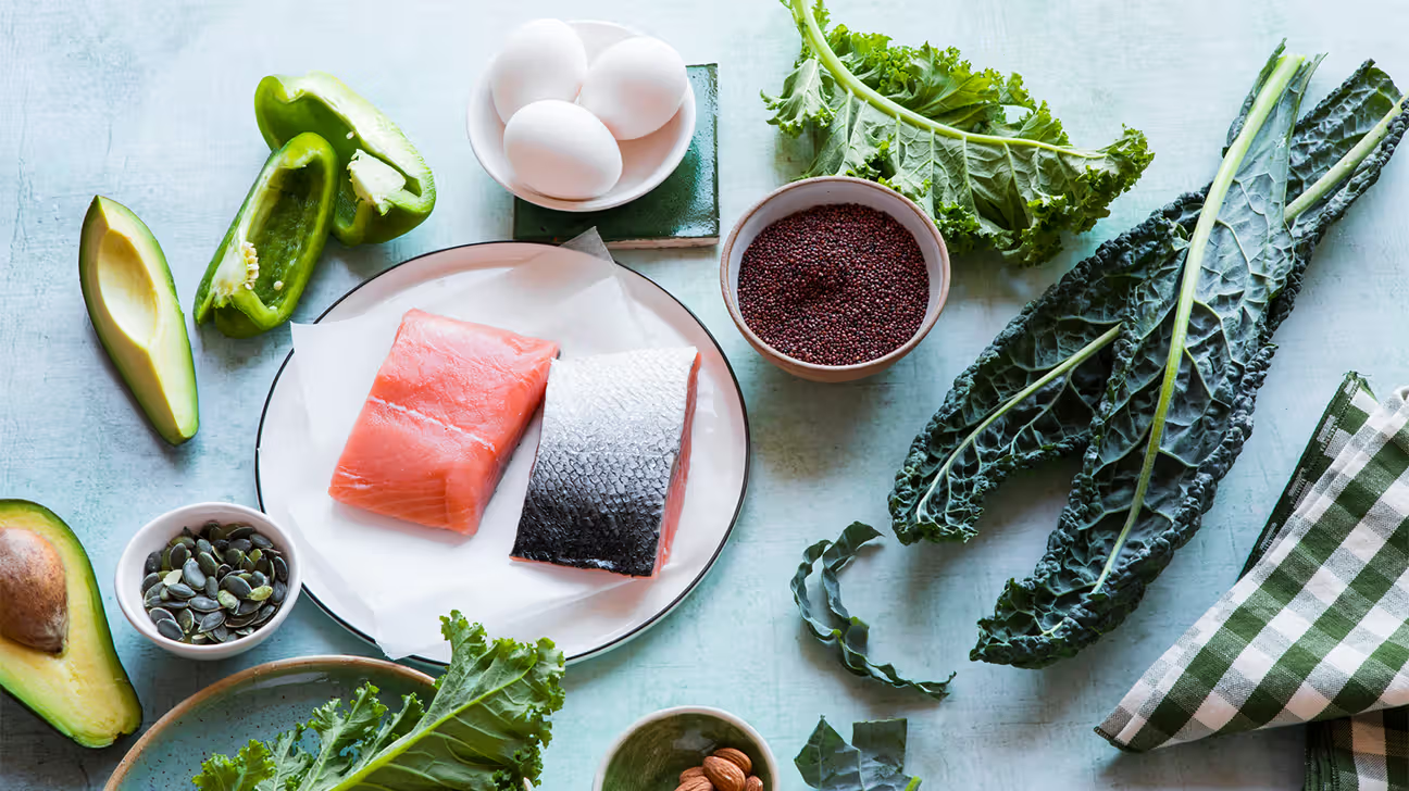 Alt text: Fresh ingredients like fish, leafy greens, and eggs displayed as sources of essential nutrients.