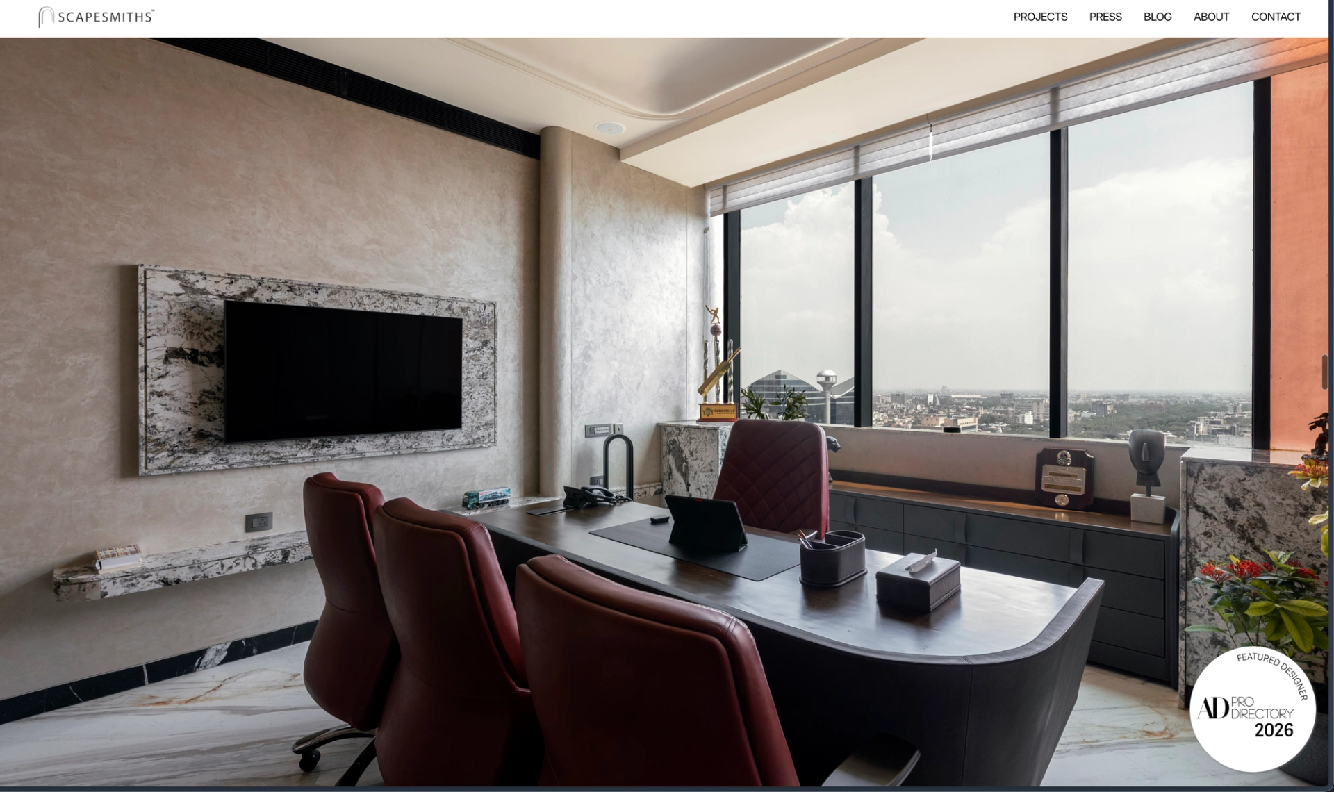 Scapesmiths website homepage showing a private office with a marble TV wall, red leather chairs and a city view