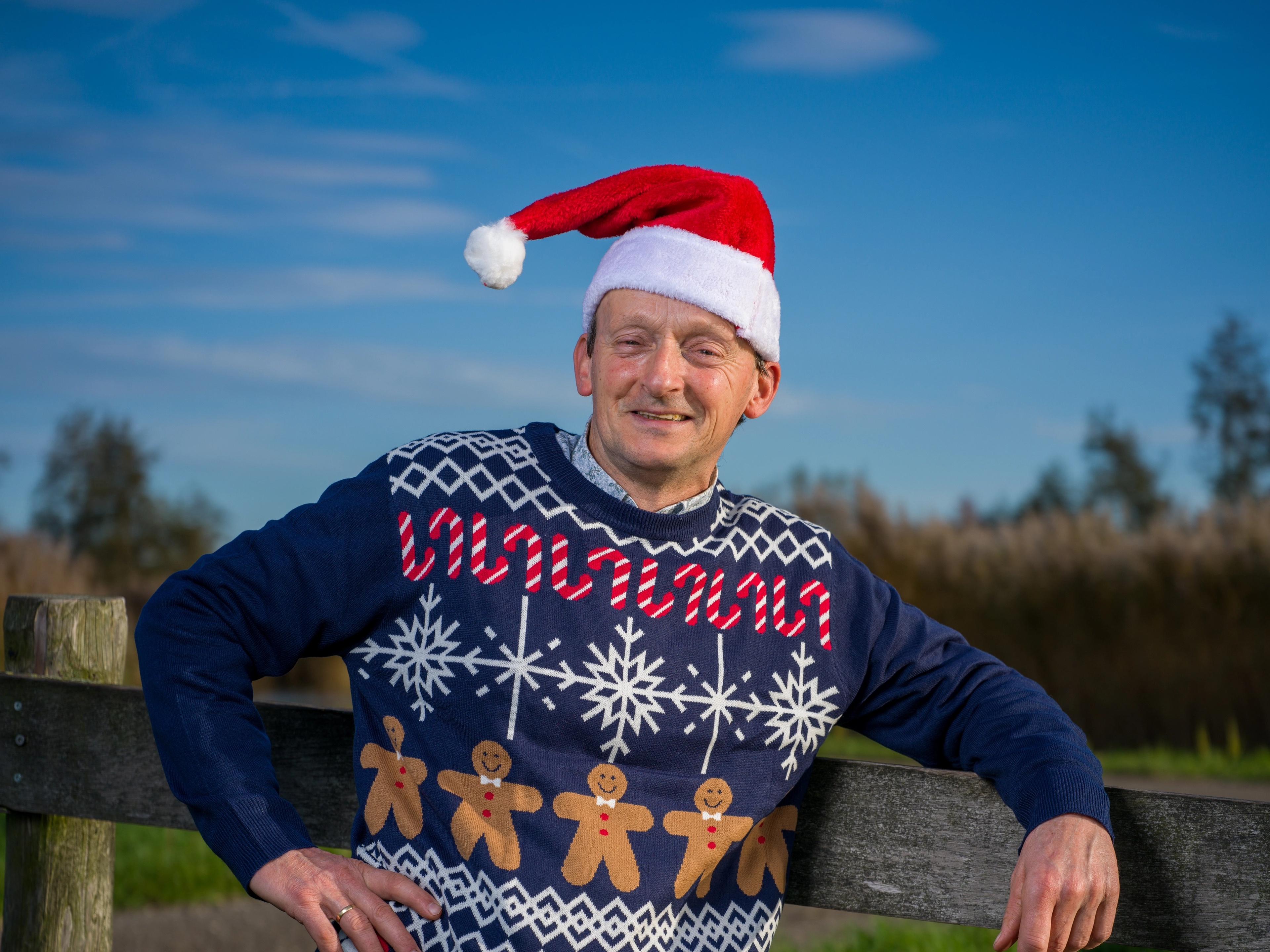 Voorzitter Cees Slob voor boerenhek met kerstmuts