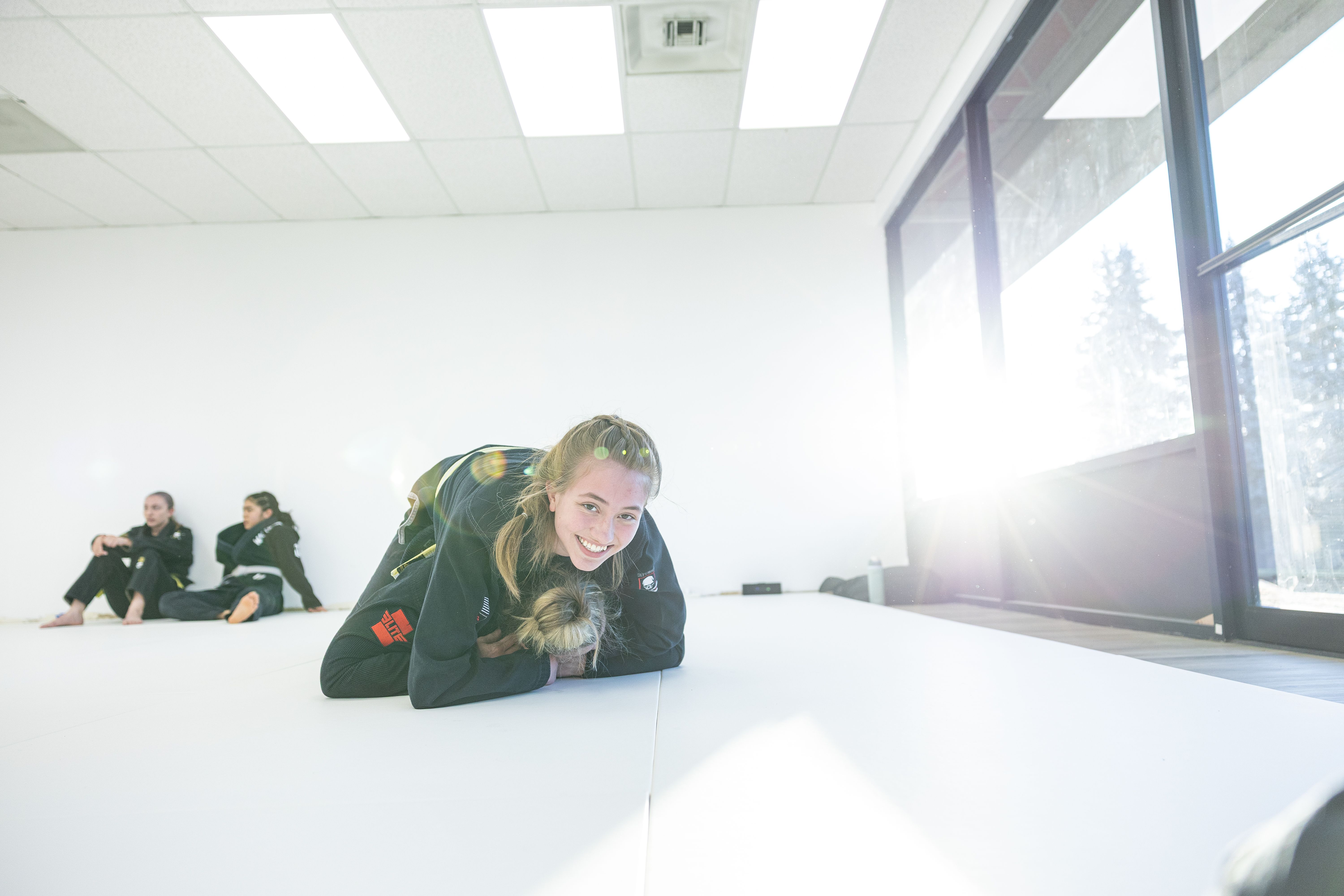 Student smiling while grappling during class at Via Jiu Jitsu