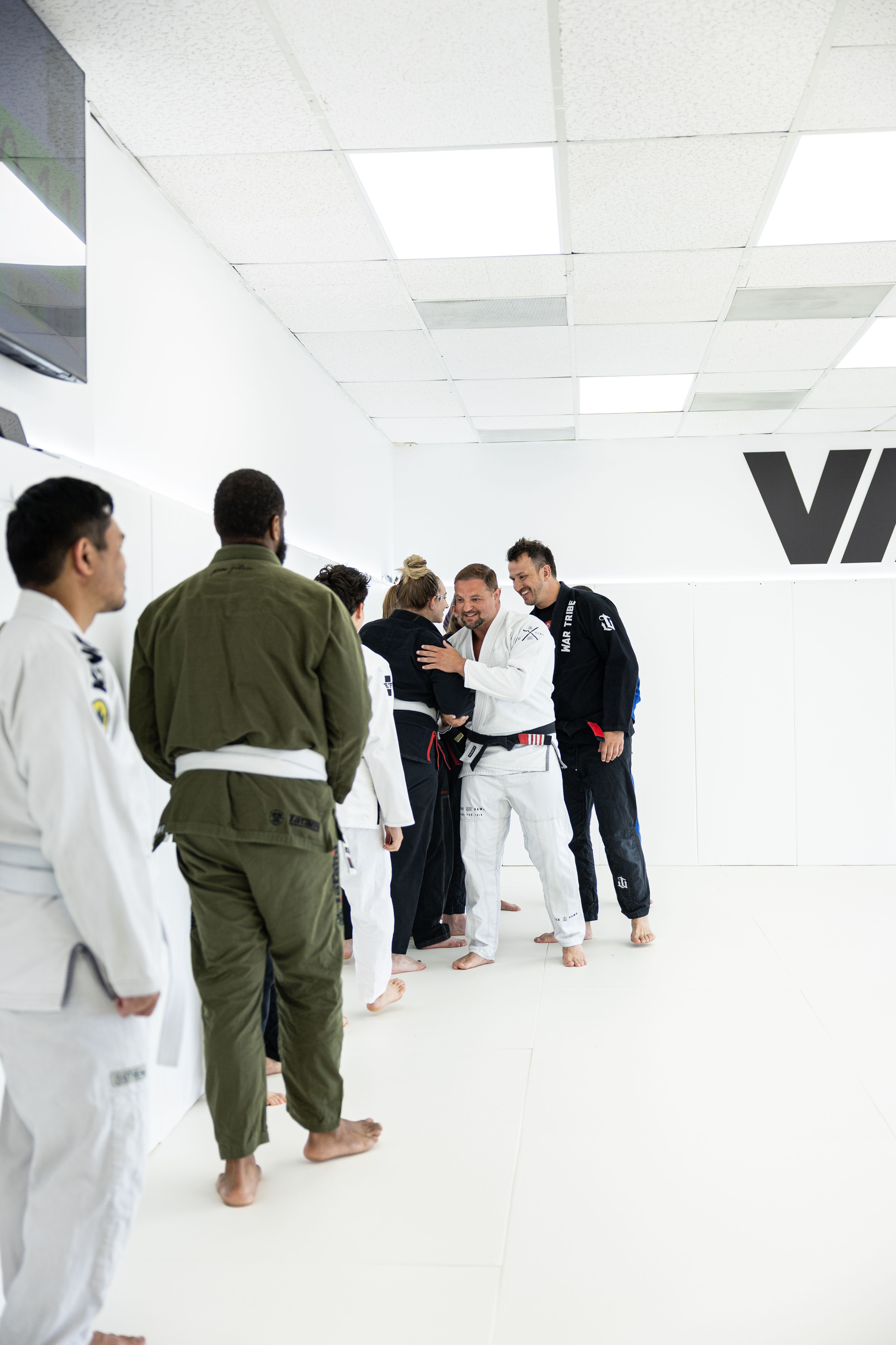 Students lining up and greeting each other on the mat at Via Jiu Jitsu