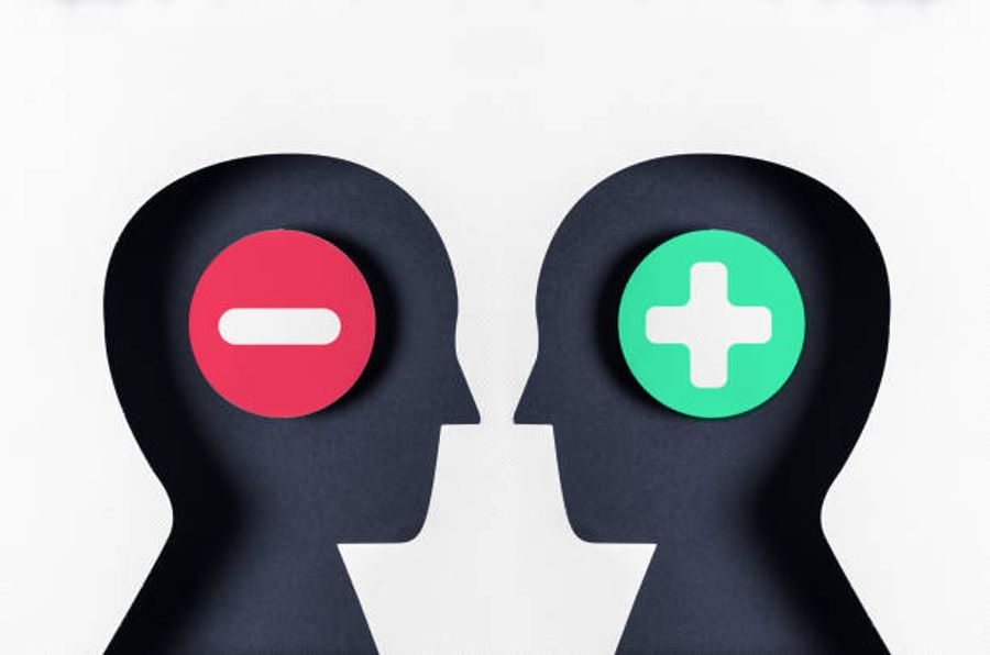 Two silhouetted heads facing each other, one with a red minus symbol and one with a green plus symbol, representing customer objections versus confidence in a purchase decision.