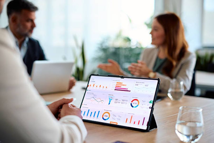Business team reviewing analytics dashboard data on a tablet during a meeting.