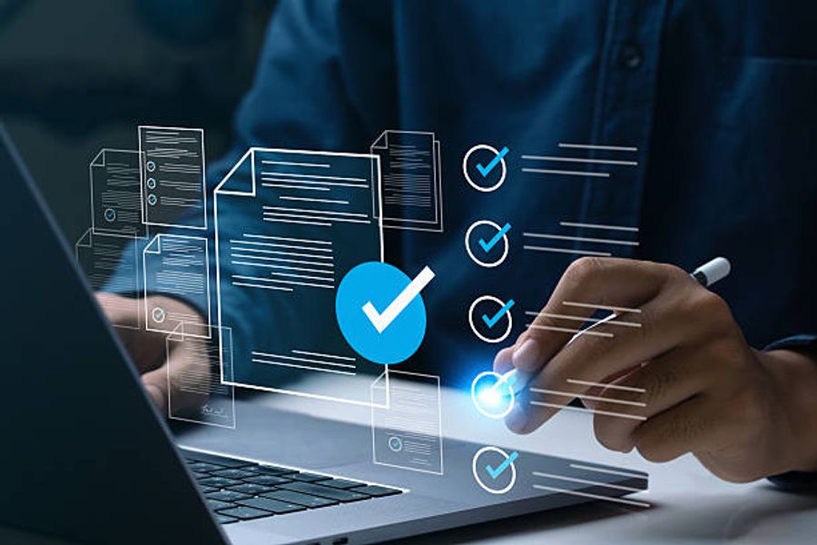 Person working on a laptop with a digital checklist and verification icons overlaid representing an audit or quality review process.