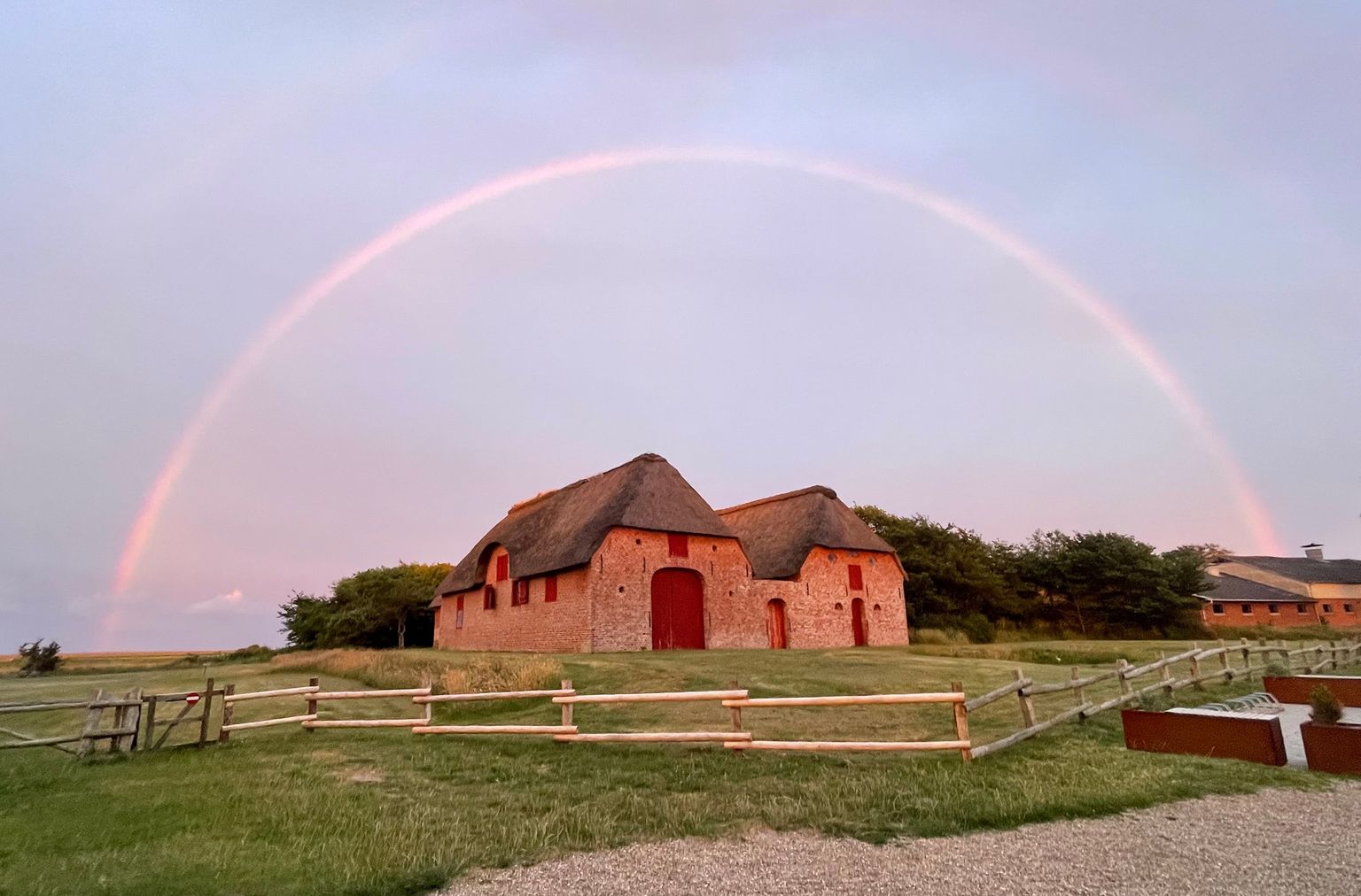 Rainbow over The Sea Captain's House thatched barn in evening light. Photo: Birgit Kleist Pedersen