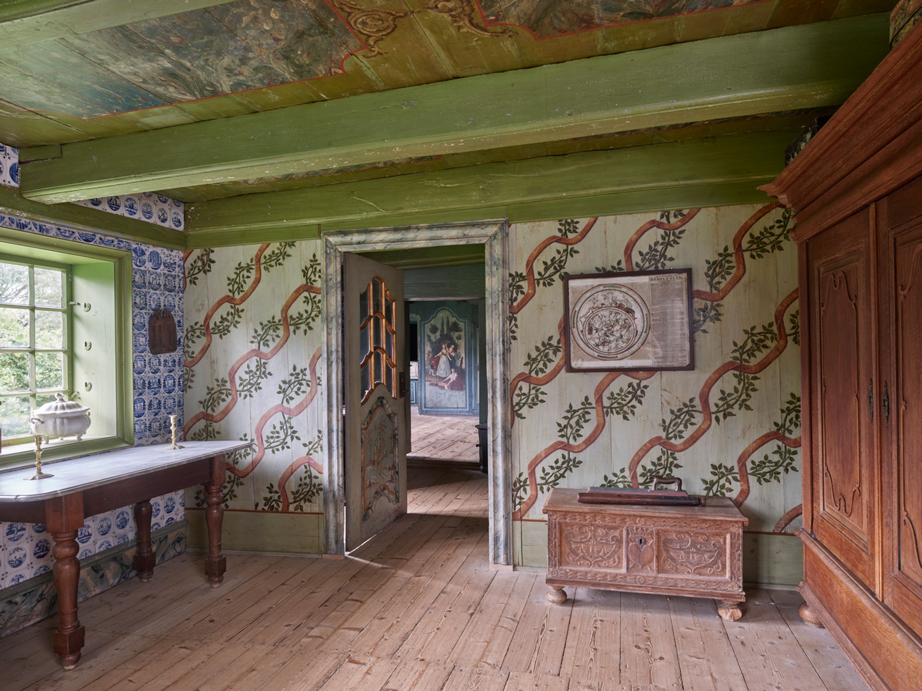 Stue i Kommandørgården med blomstermalet vægdekoration, bemalede døre, udskåret kiste og malet bjælkeloft