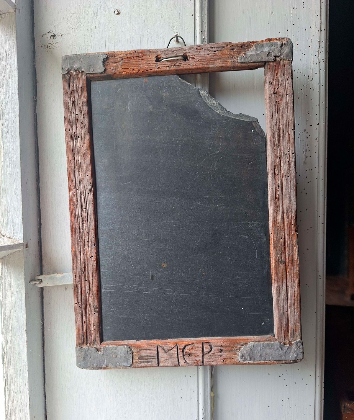 Gammel skifertavle med træramme og initialer ridset i bunden, fra Toftum Skole på Kommandørgården