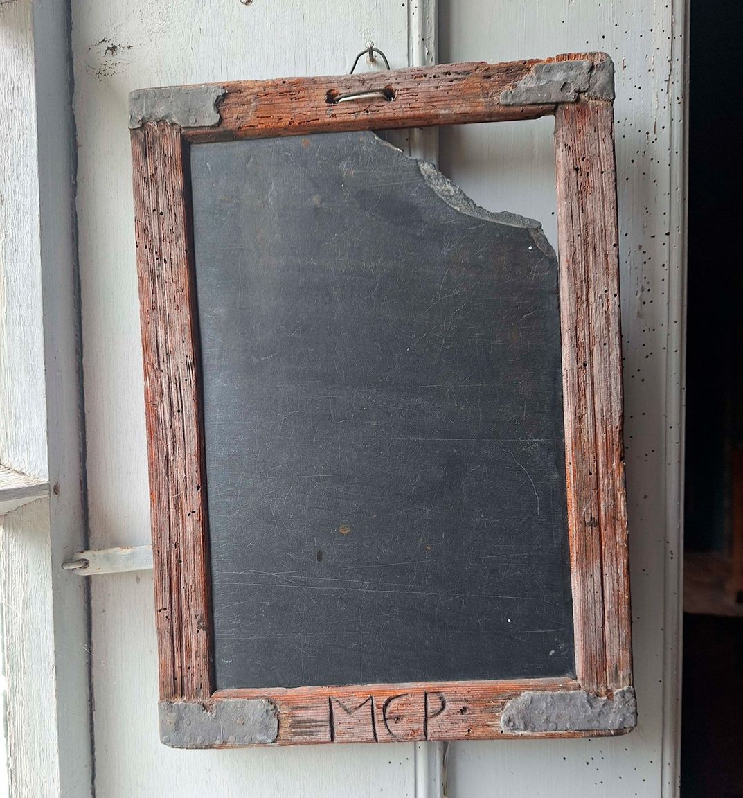 Gammel skifertavle med træramme og initialer ridset i bunden, fra Toftum Skole på Kommandørgården