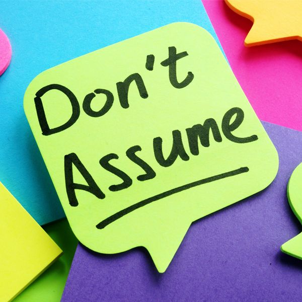 Post-it sticker with the sentence "Don't assume" spelt on it.