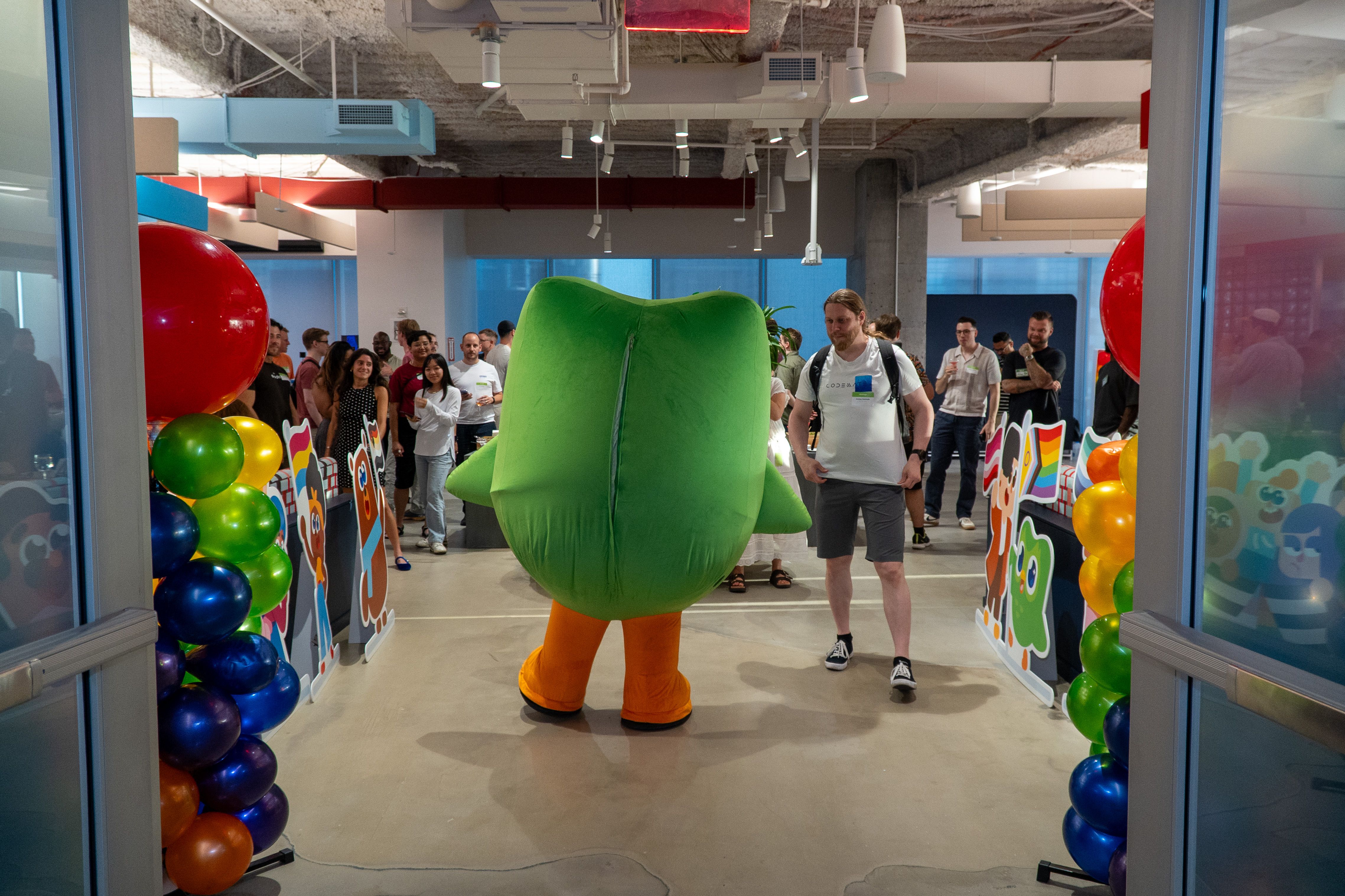Joonas Kerttula meeting Duolingo’s green owl mascot, Duo, at the speaker party in the Duolingo office.