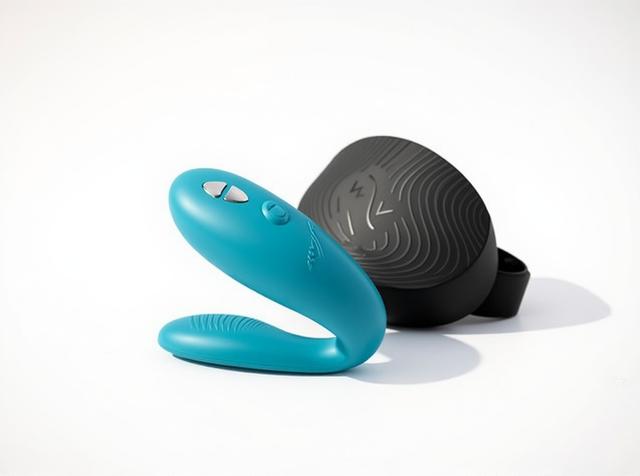 The Lovense Lush 4 Bluetooth egg vibrator in close crop on a plain white background, its curved pink silicone loop and rounded body catching soft light, with the multicolor LED indicator strip lit.