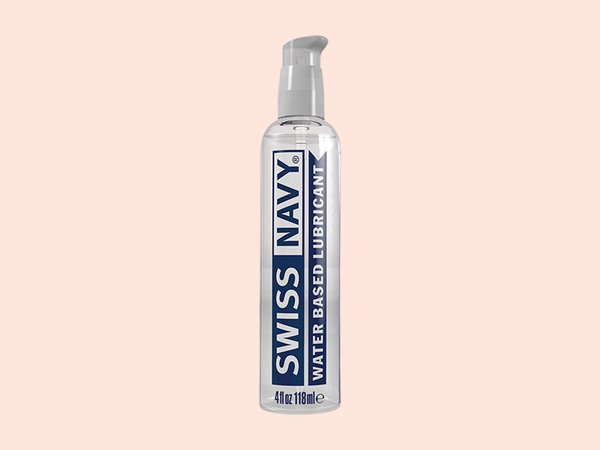 Swiss Navy Water-Based Lubricant, the everyday 4 oz pick, standing tall against a warm coral backdrop in this guide to choosing a water-based lube.