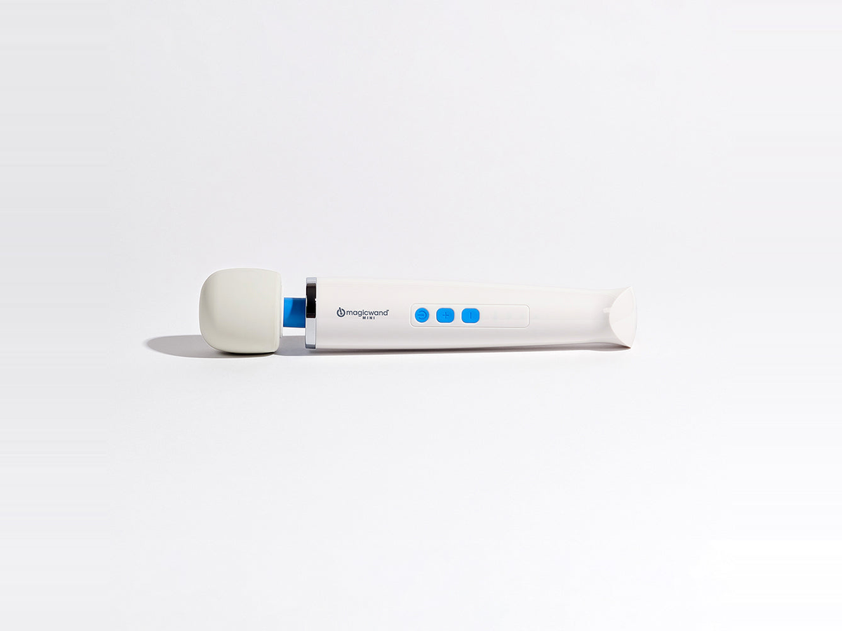 The Magic Wand Mini rechargeable vibrator lying on its side on a bright white studio surface, its rounded silicone head and slim body shown at true scale with generous open space around it, illustrating the mid-size tier between compact bullets and full-size wands.