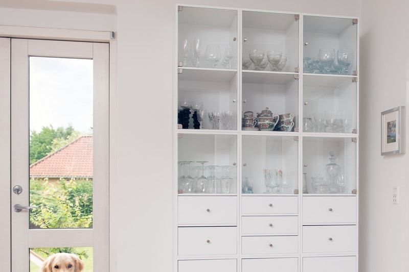 A room with a pair of french doors next to a cabinet