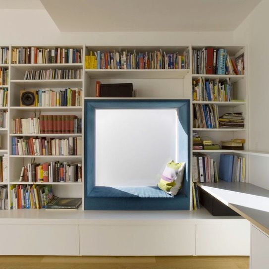 White built-in bookcase with inset reading nook on golden pine hardwood floor