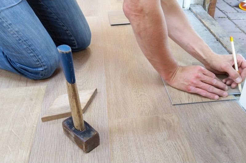 A person marking the trim along the floor