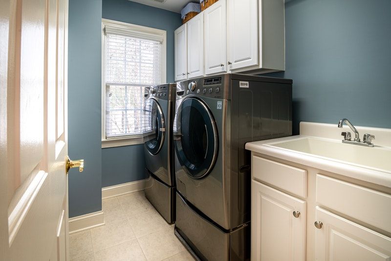 A laundry room with nicely painted cabinets