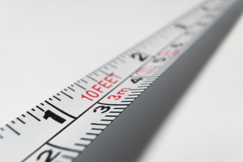 A closeup of white measuring tape along a white surface