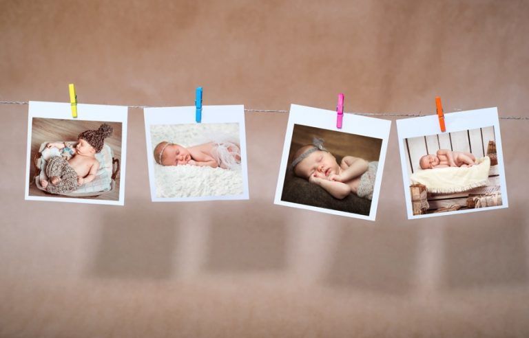 Polaroid images of babies clothespinned on a wire
