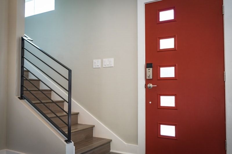 A red door with white trim next to a set of stairs