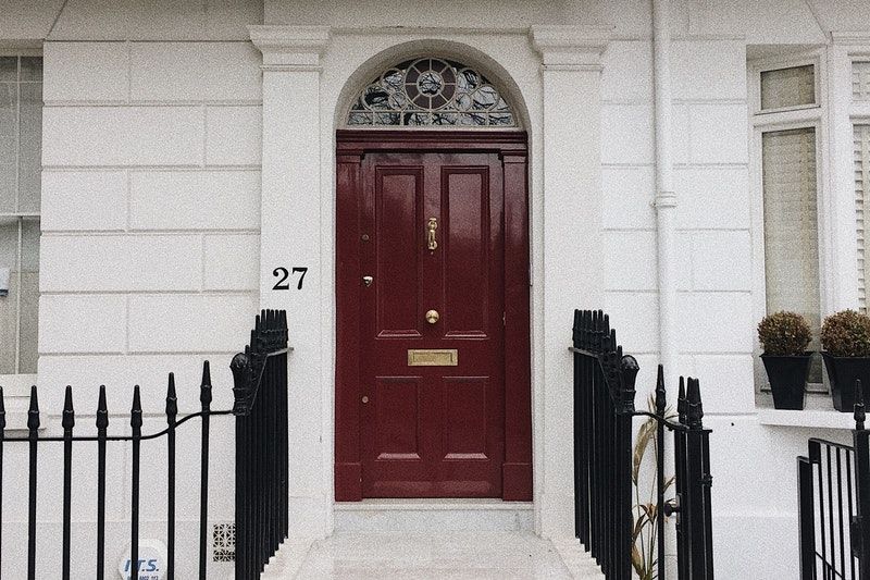 A red painted exterior door in the entrance to a house