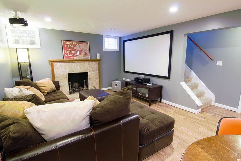 A painted basement living area with gray walls and a white ceiling
