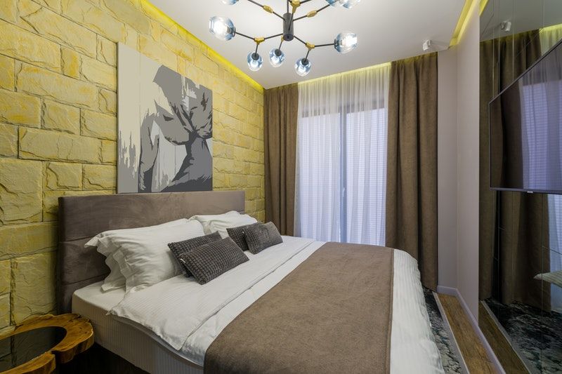 A bedroom with yellow painted brick