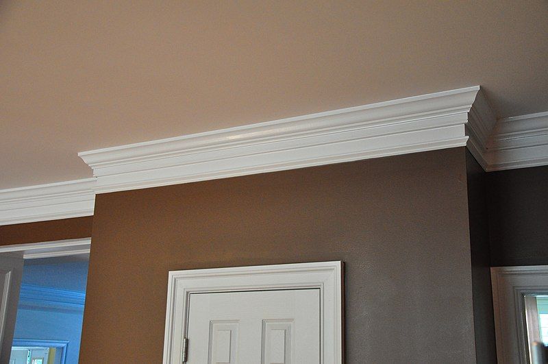 White, wooden crown molding running along the ceiling