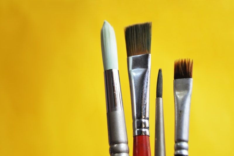 A closeup of four artist’s brushes