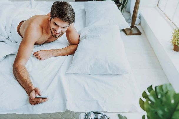 homem sorrindo escrevendo mensagem de texto