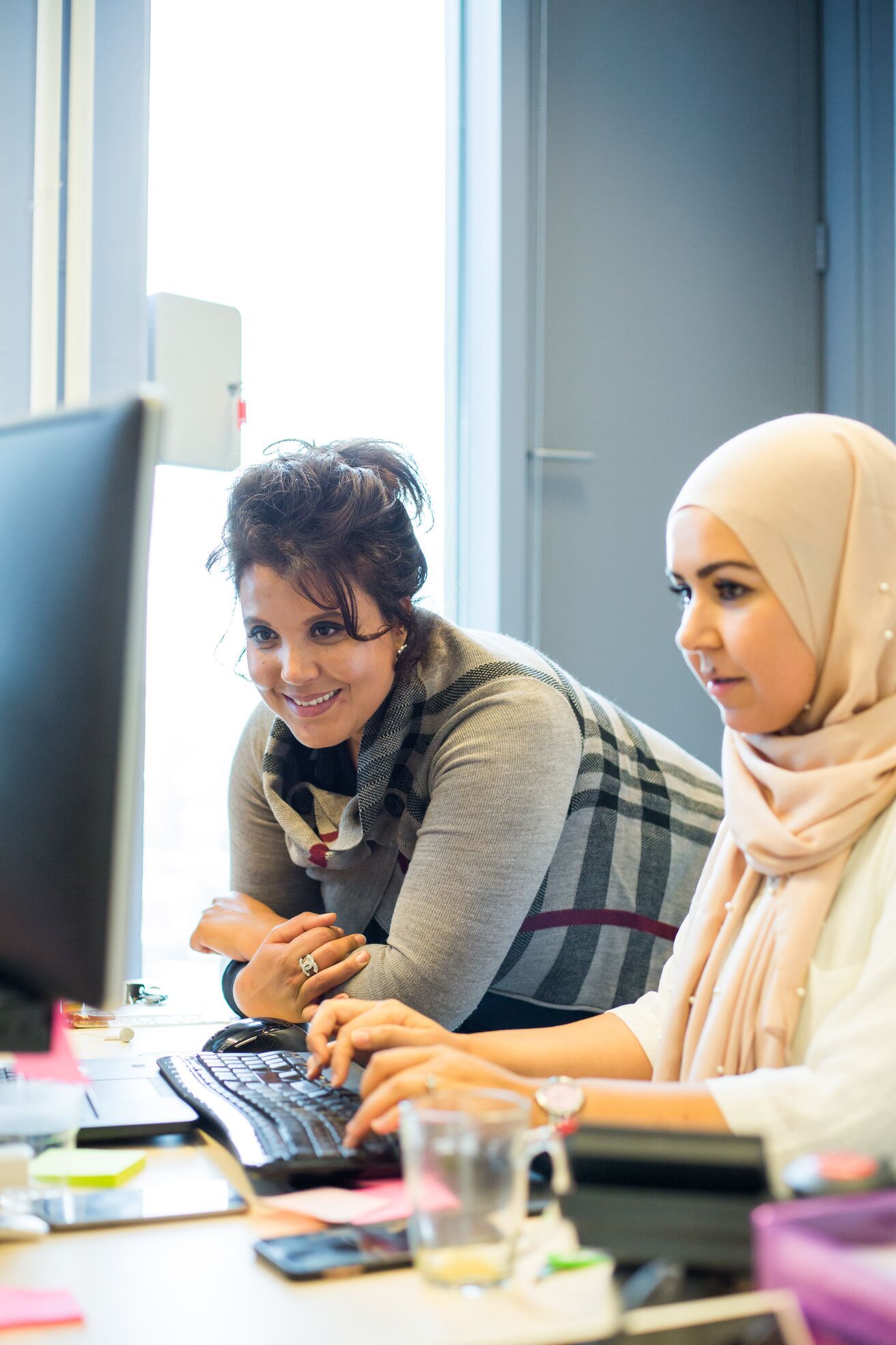 Twee mensen achter een computerscherm