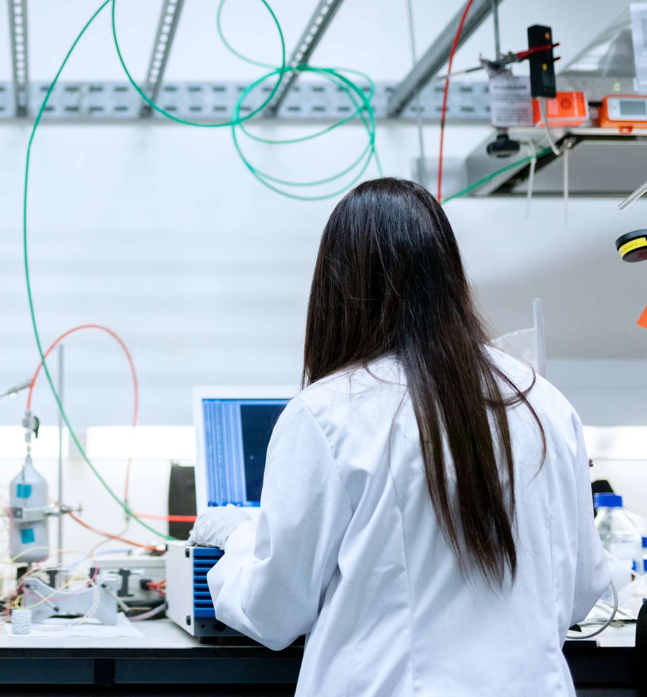 Person from behind in lab coat in an engineering lab