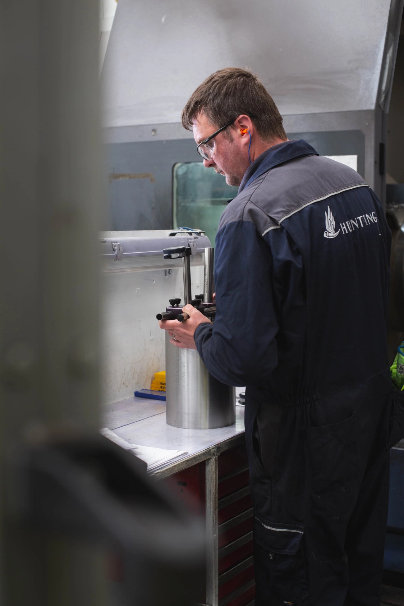 Person in Hunting overall testing a tubular device