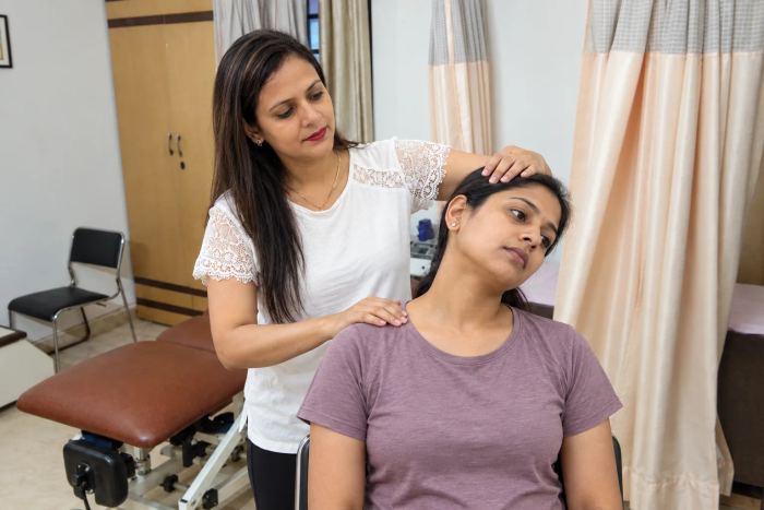 Illustrative physiotherapy scene based on the clinic room, showing a neck and shoulder assessment
