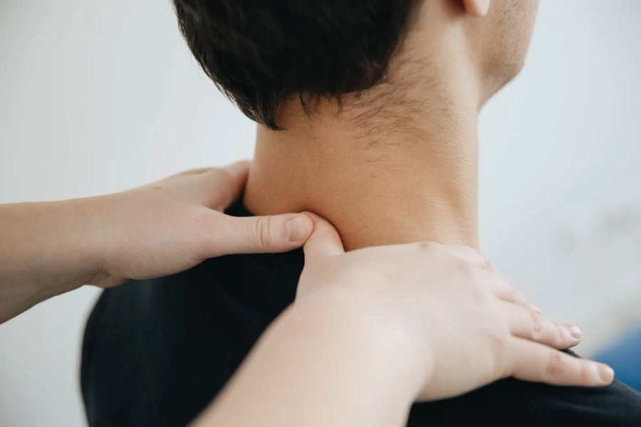 Stock photograph of hands supporting a person’s neck and shoulder