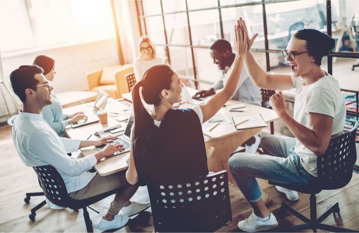 Equipo de trabajo celebrando al cumplir objetivos de posicionamiento