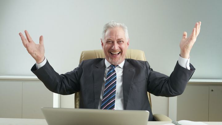 Old man smiling due to the success of his own business