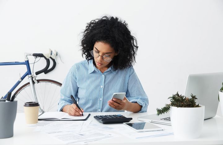 Mujer realizando cálculos en su oficina