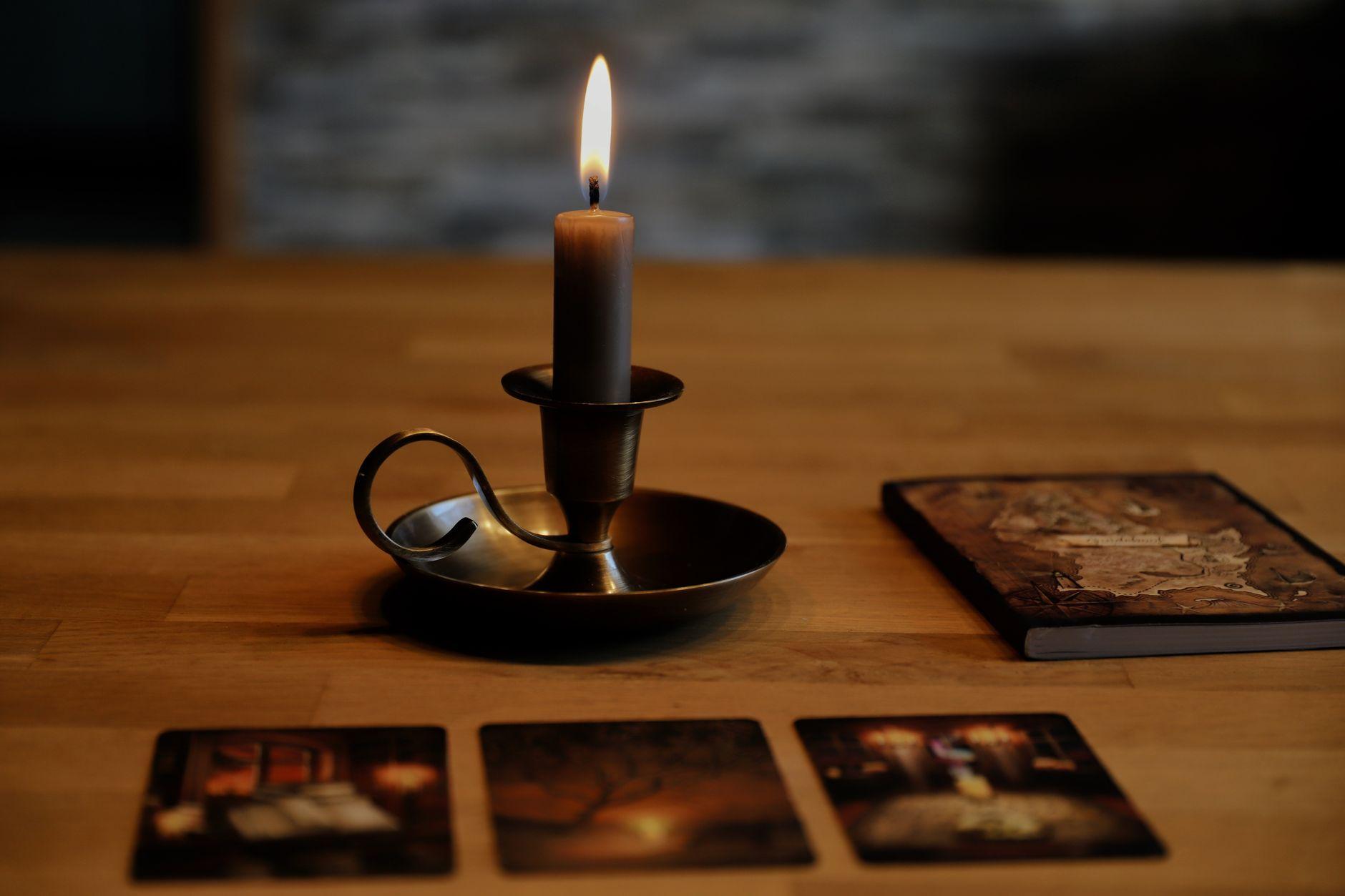 Candlelit tarot cards and an old book laid out on a wooden table, evoking a mystical reading about second chances