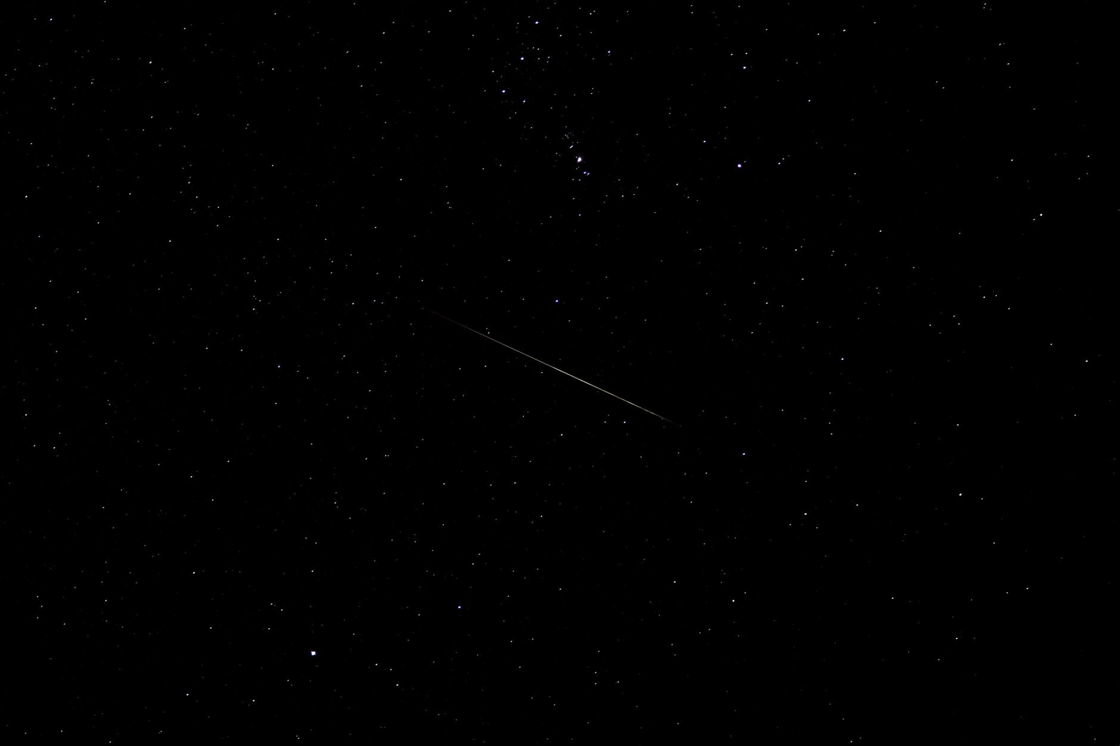 A shooting star crossing a deep, star-filled night sky