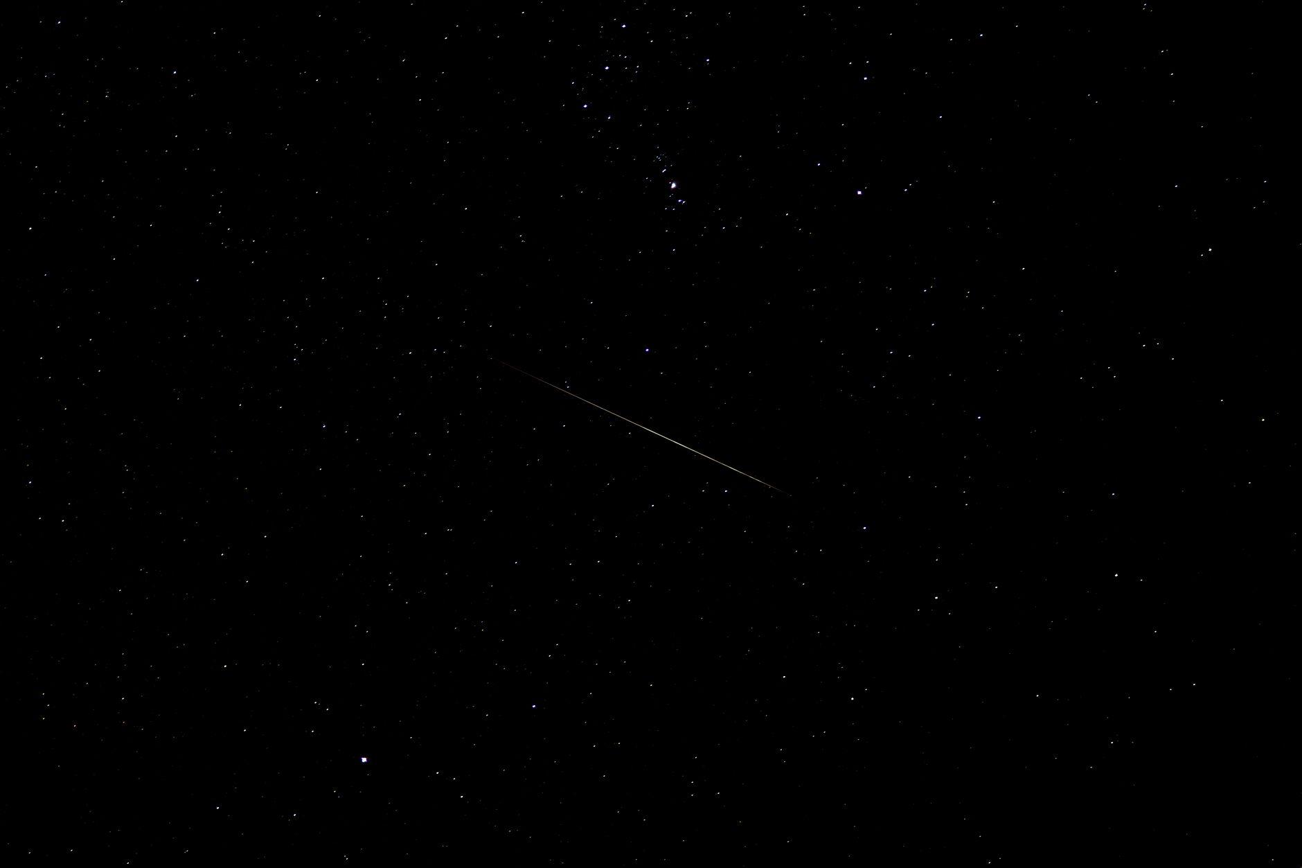A shooting star crossing a deep, star-filled night sky