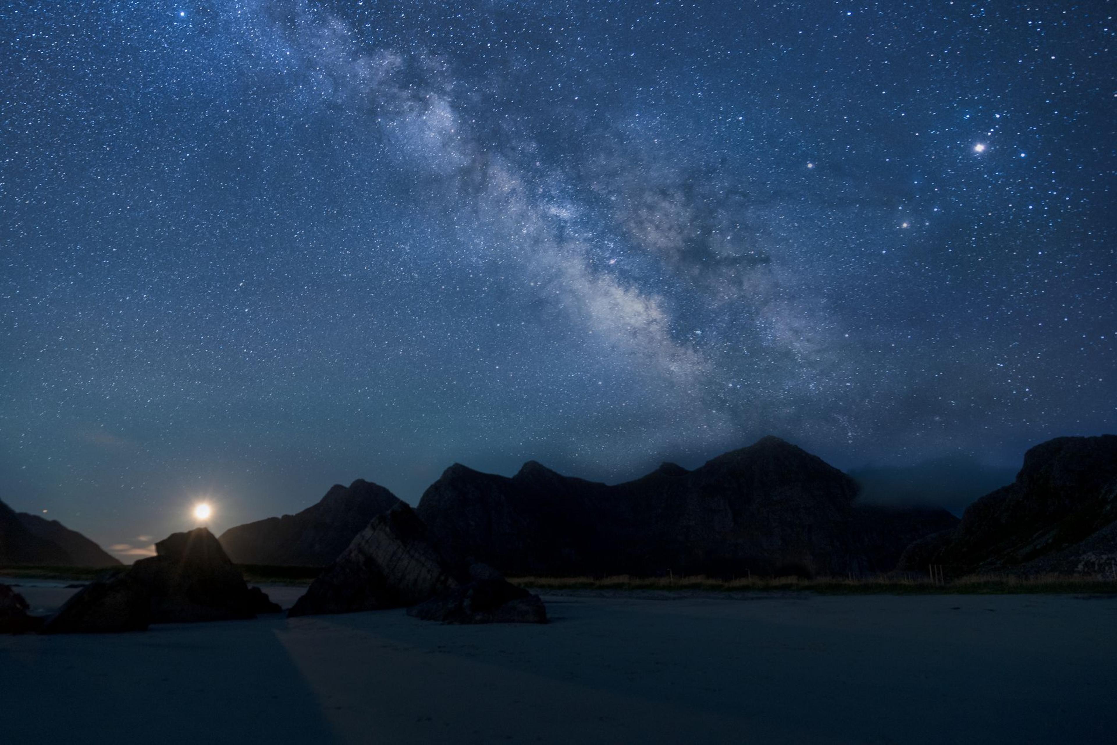 The Milky Way stretching over a mountain range and lake at night