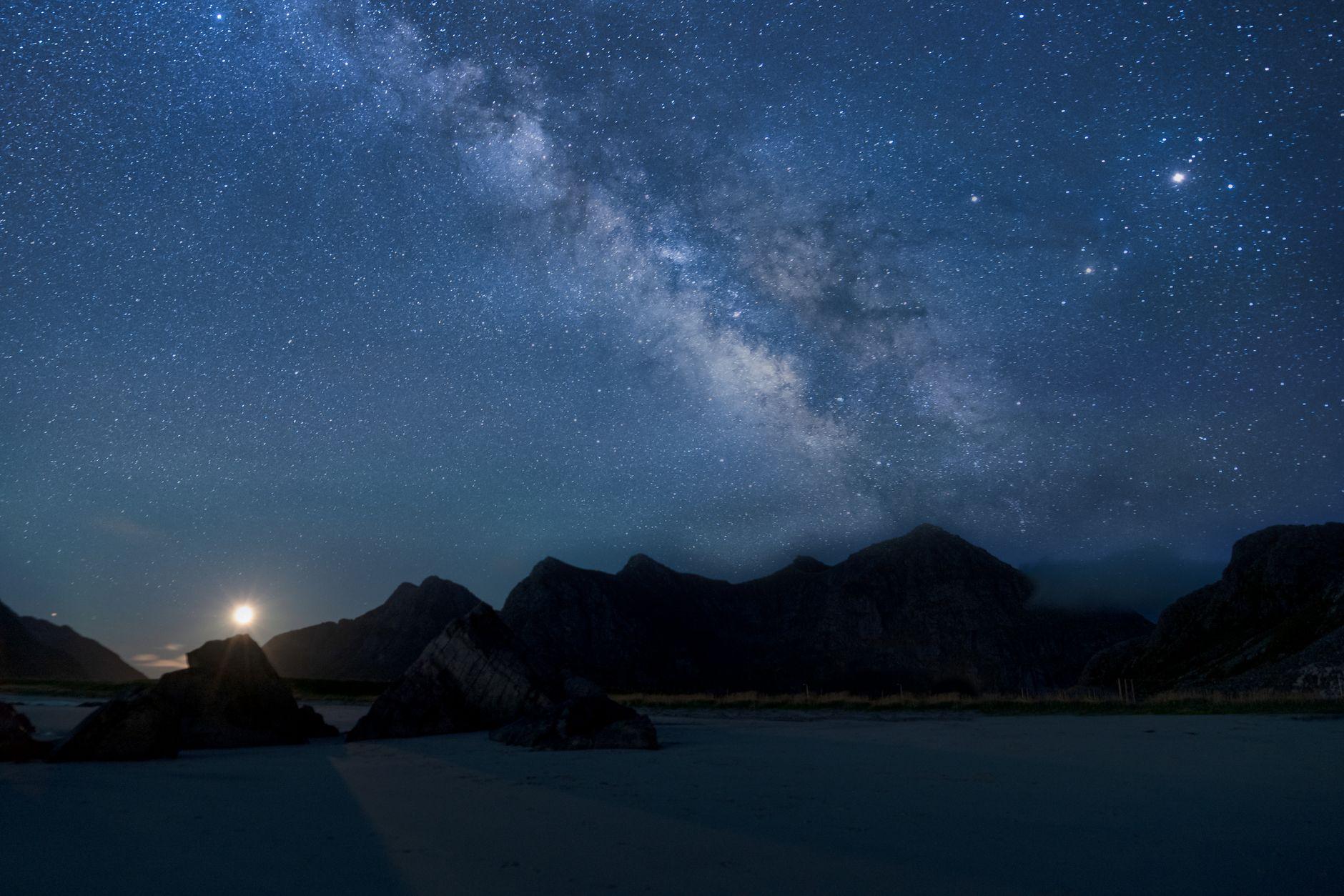 The Milky Way stretching over a mountain range and lake at night