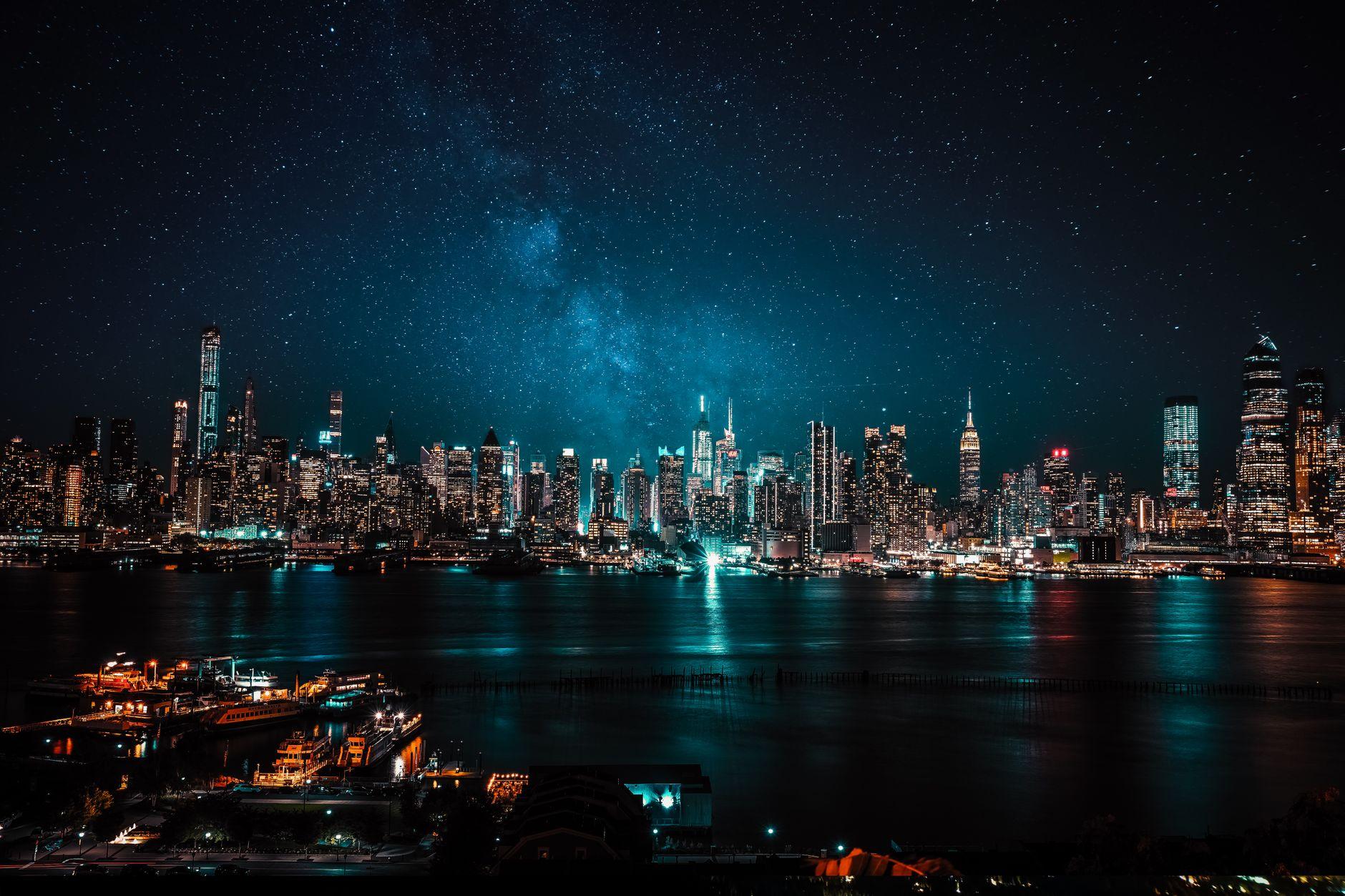 City skyline glittering under a starry night sky, evoking award-season glamour